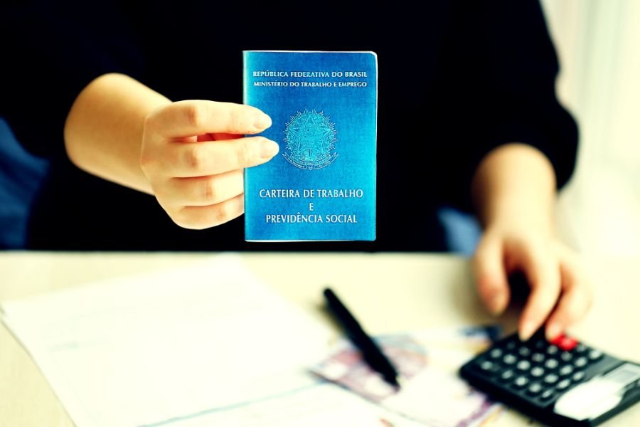 Empregada doméstica analisando documentos sobre FGTS e INSS em casa.